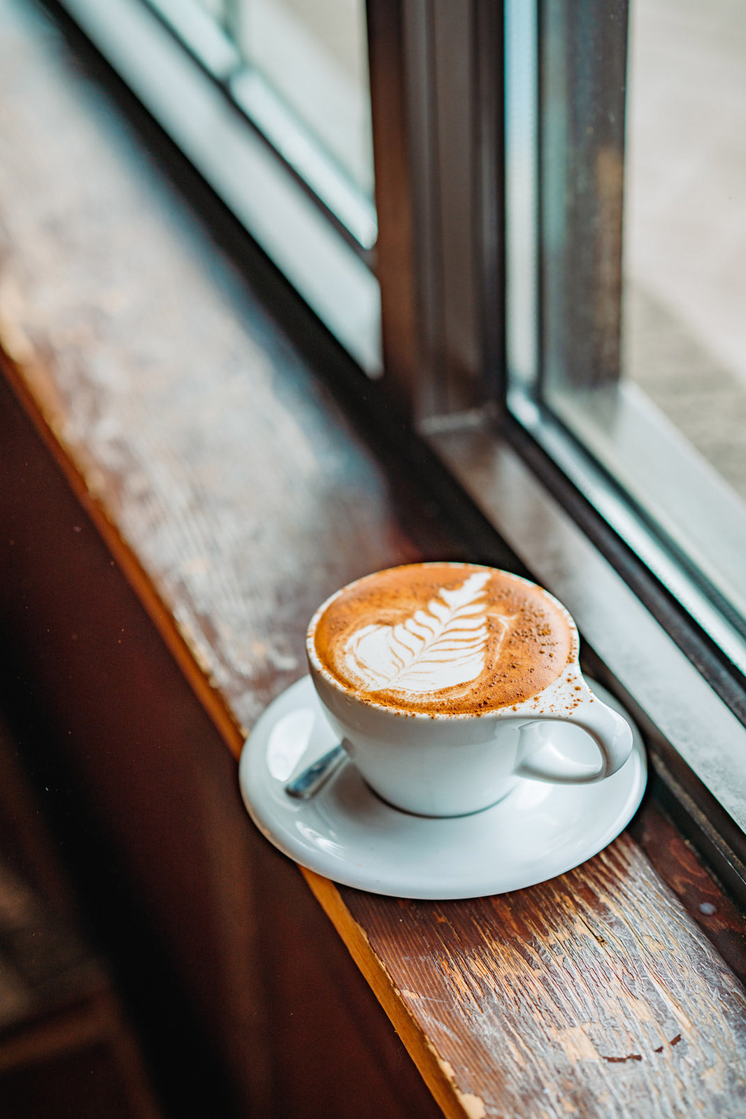 Picture of a latte sitting on a cafe window sill.