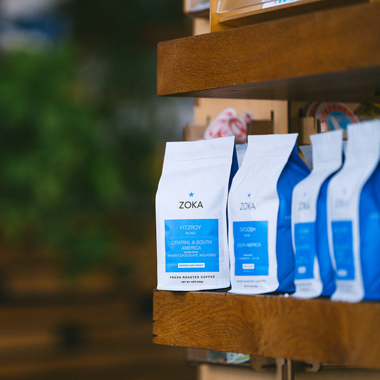Zoka coffee bags on a wooden shelf.